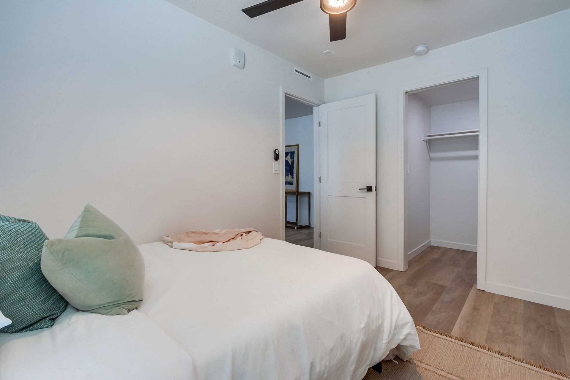 Photo showing a bedroom with a closet that is somewhat a walk-in closet
