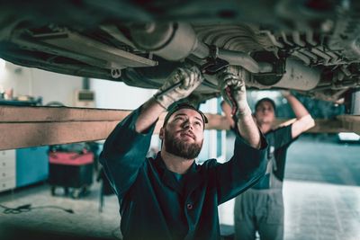 Two Mechanics Repairing Exhaust System — Huntsville, AL — Worth Exhaust Center Two Mechanics Repairing Exhaust System — Huntsville, AL — Worth Exhaust Center