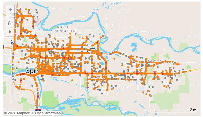 Map of a city with orange road lines and blue rivers, showing a dense urban grid along a river corridor.