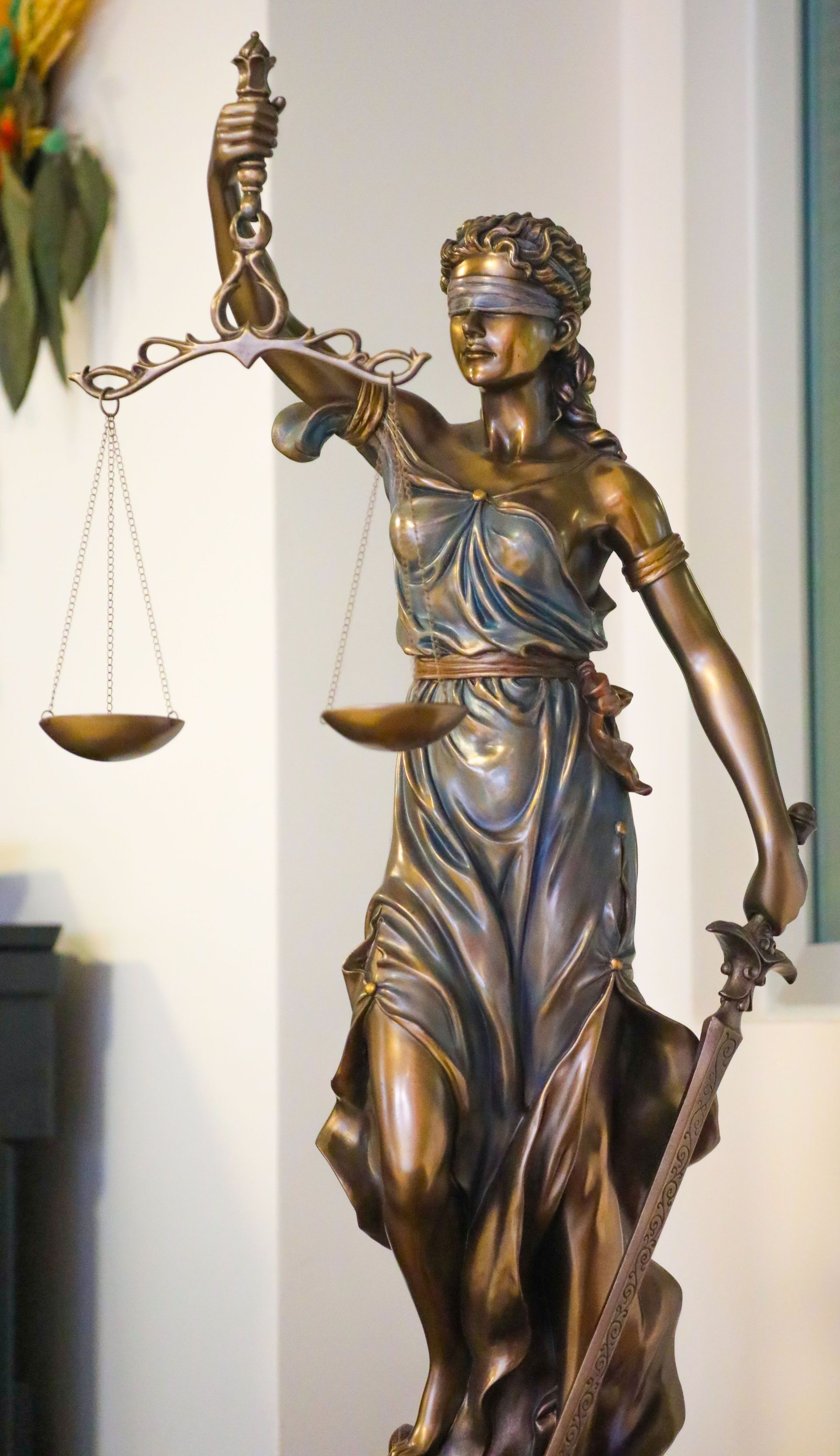 Bronze statue of a woman with a blindfold, holding scales and a sword.