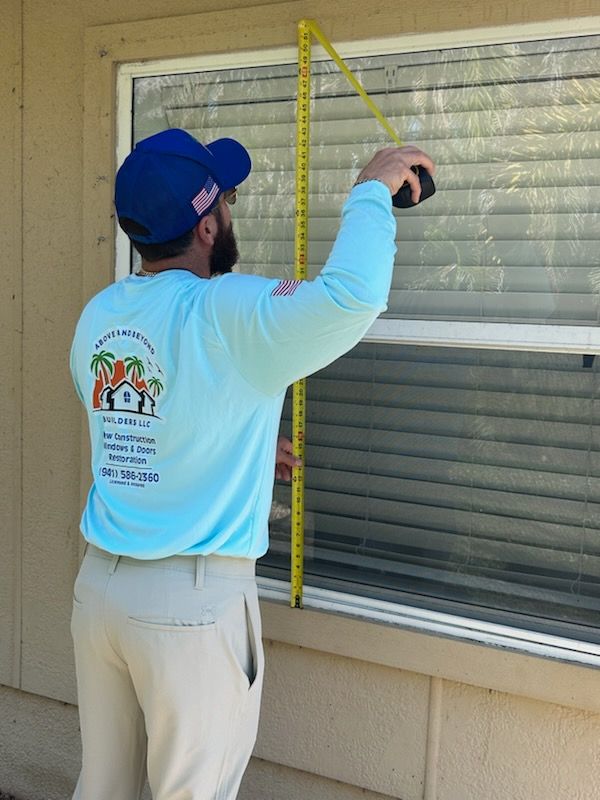 A man measuring a window with a tape measure
