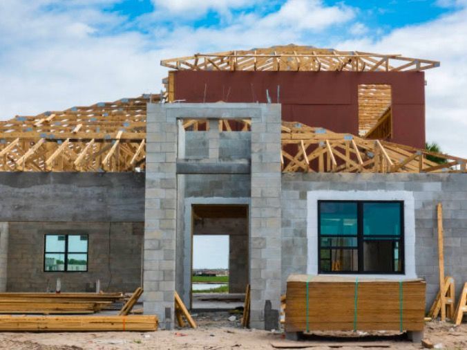 A house is being built with wooden beams and bricks.