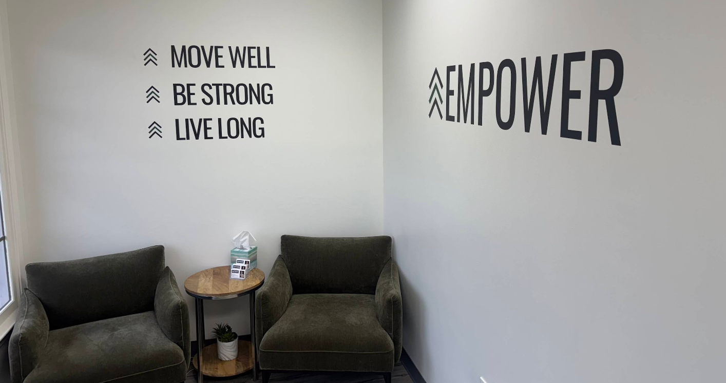 Two armchairs face motivational wall art: 