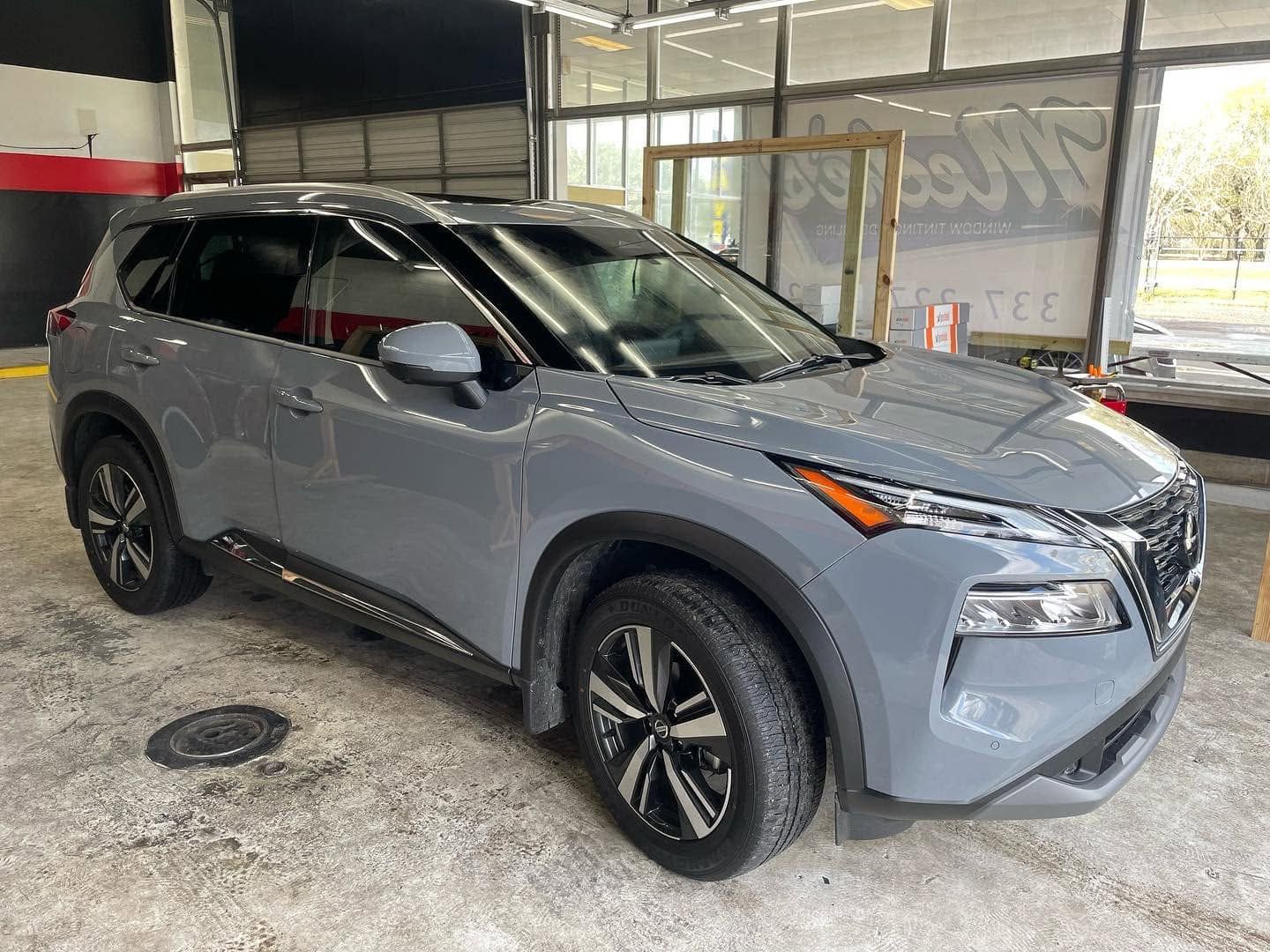 Gray Nissan SUV parked in a garage, angled front-left view