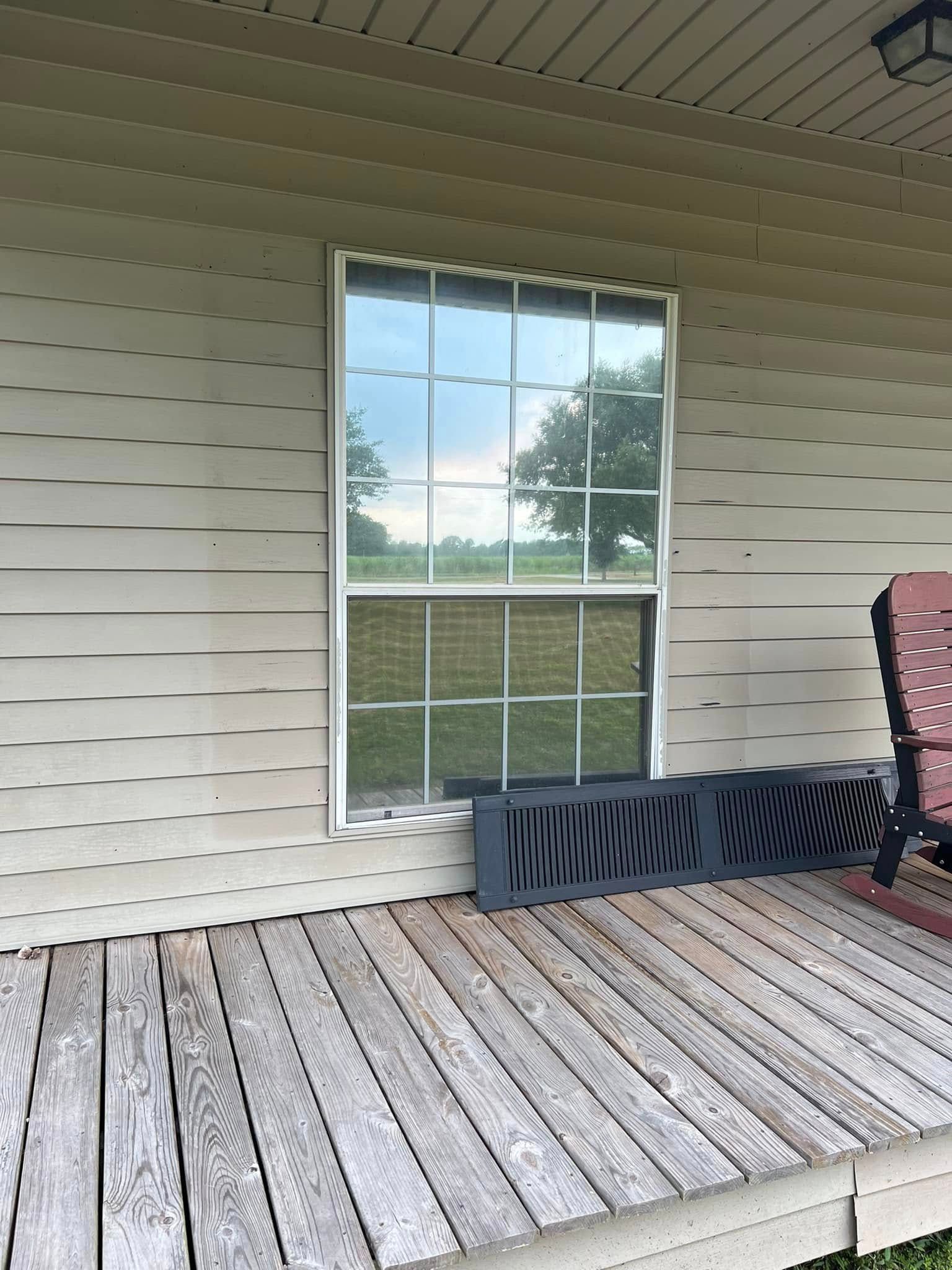 Covered porch with white siding, a window, and a wooden deck floor.