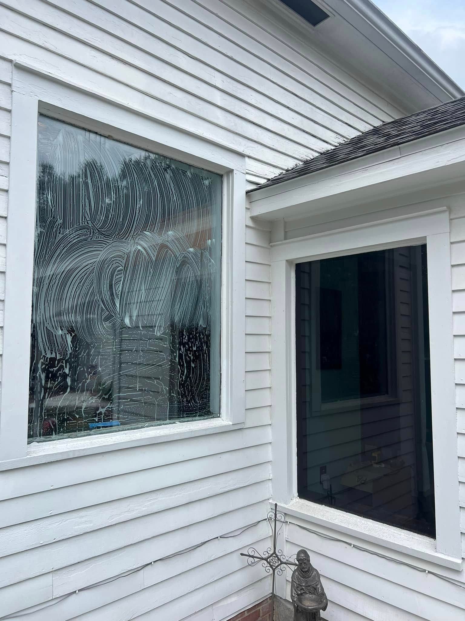 White house exterior with a large frosted window and a dark screened doorway on the side.