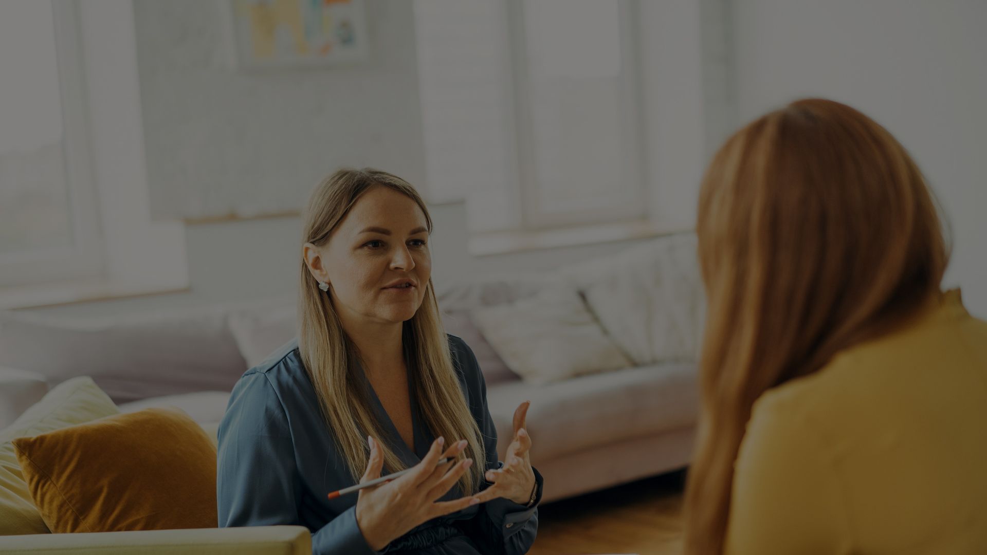 Woman talking to another person in a therapy session.