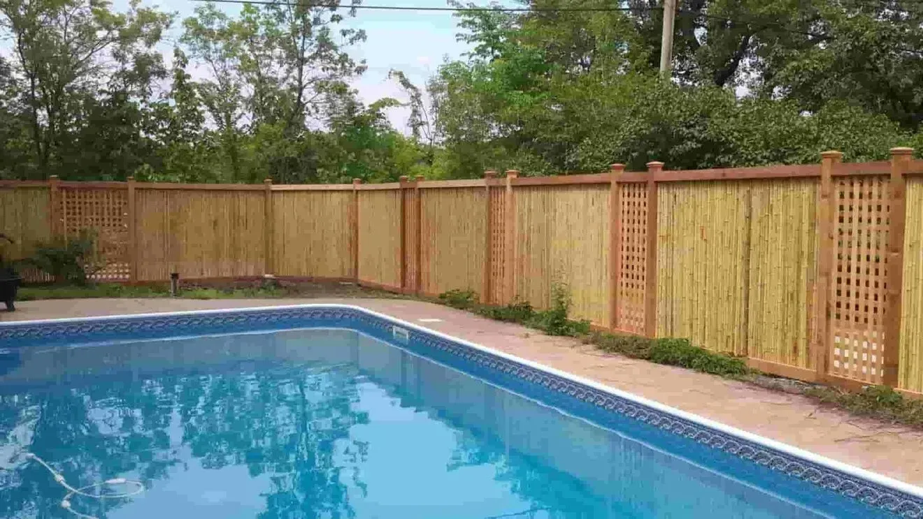 A large swimming pool surrounded by a wooden fence.