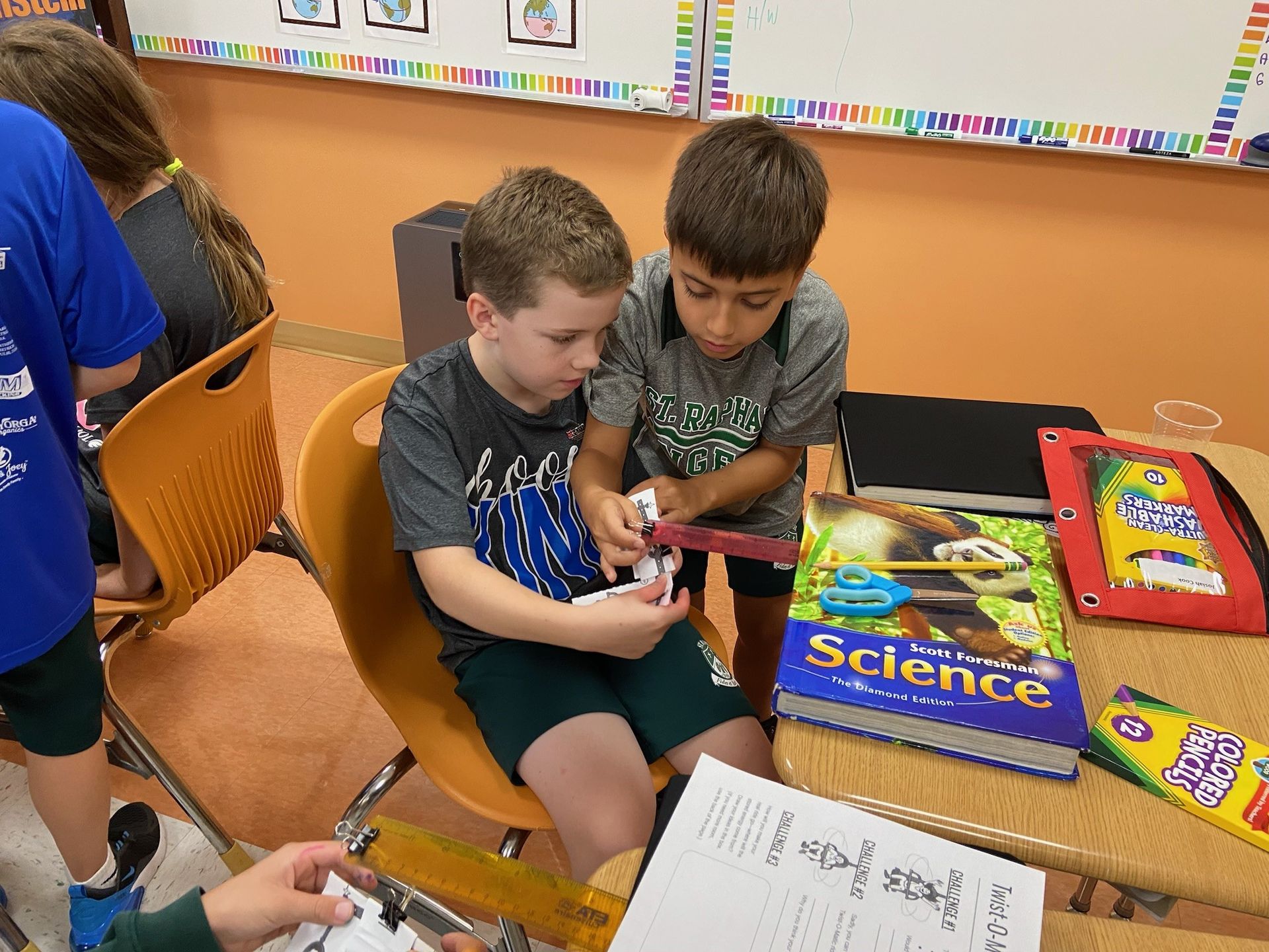 A group of children are sitting around a table reading books