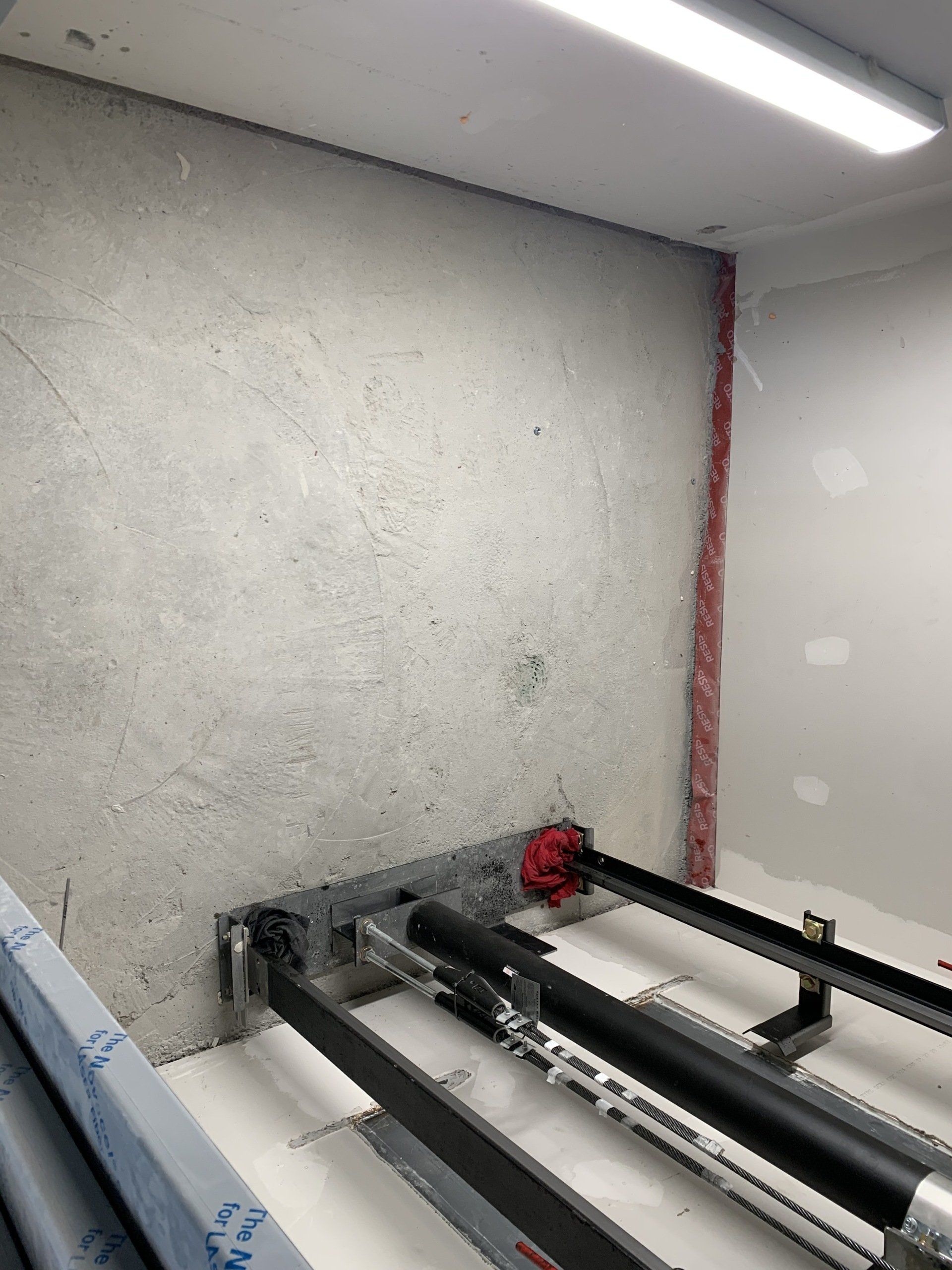 Une pièce avec un mur en béton et une machine à l'intérieur.