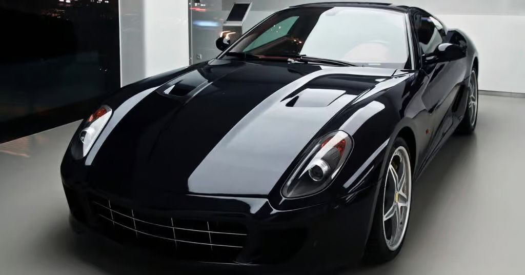 Black sports car with silver racing stripes in a showroom