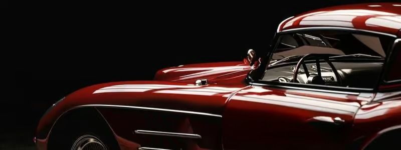 Glossy red vintage sports car close-up on a black background