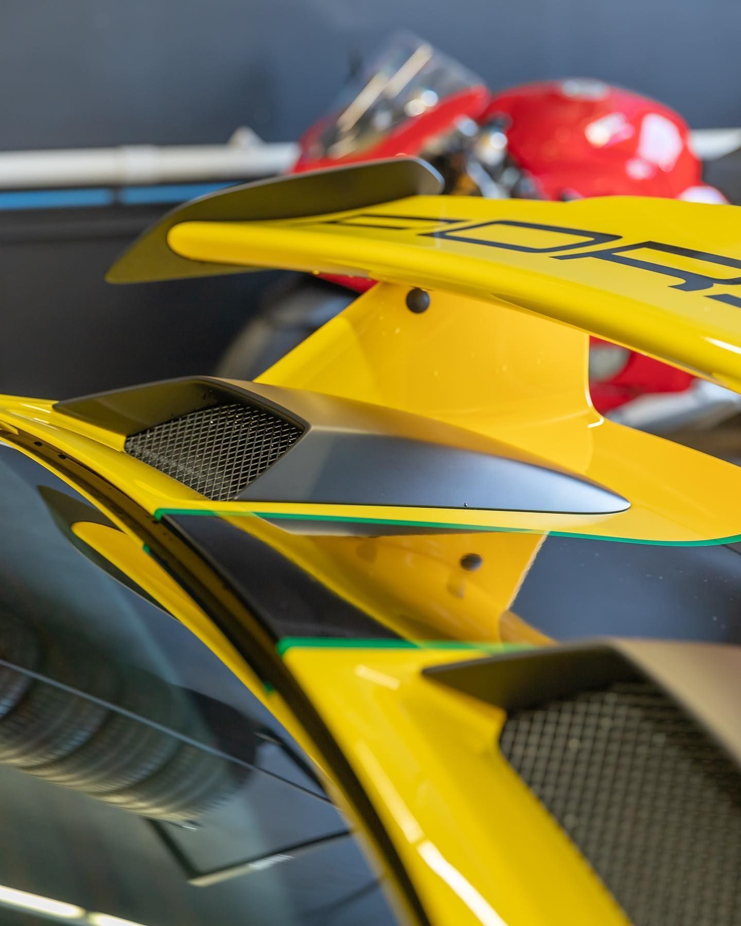 Close-up of a yellow race car’s rear wing and aerodynamic body panels
