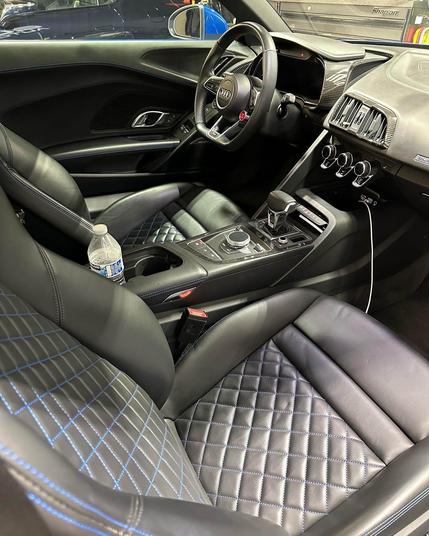 Luxury car interior with black quilted leather seats, steering wheel, and center console