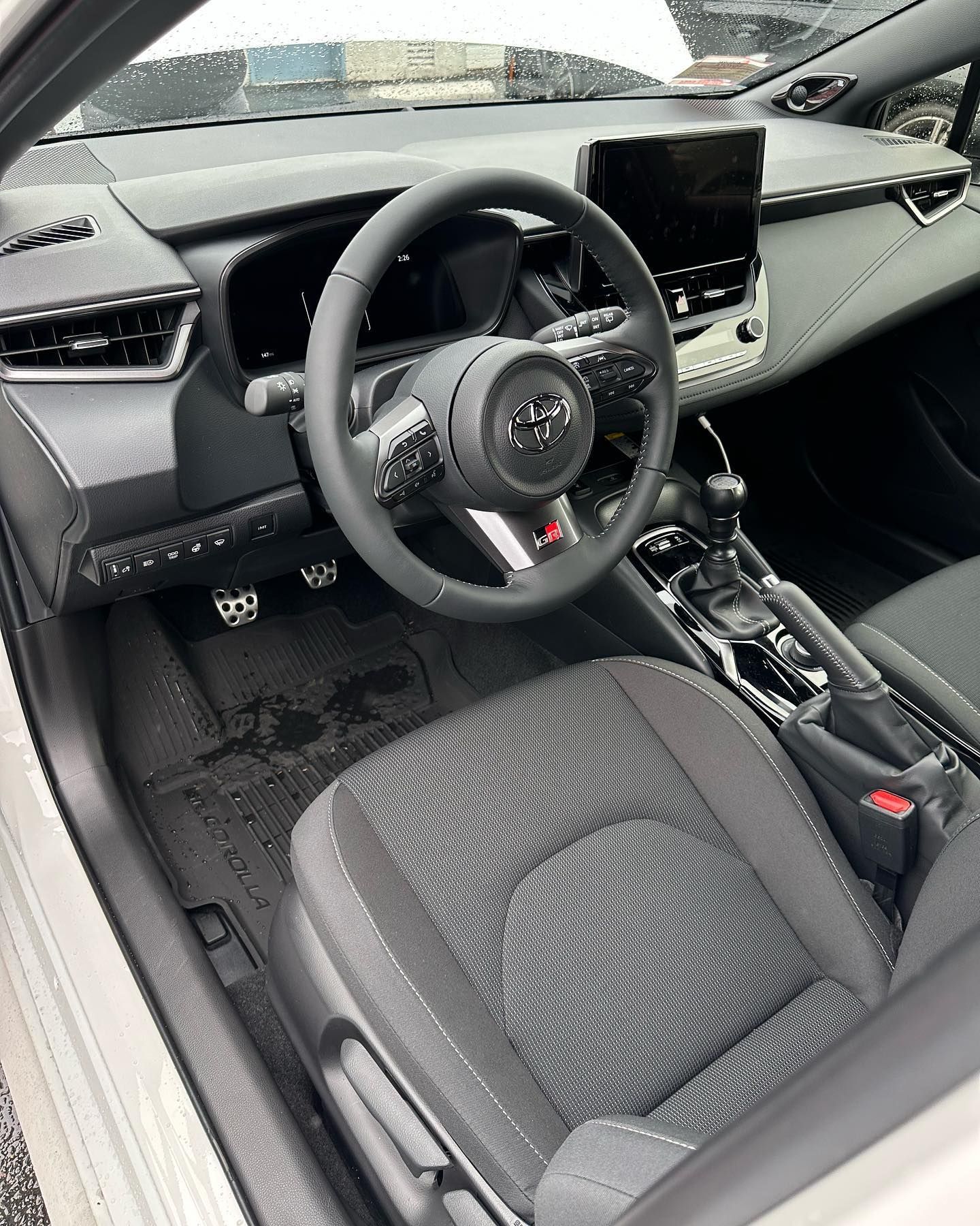 Interior of a modern Audi car, showing the driver’s seat, steering wheel, dashboard, and center console.