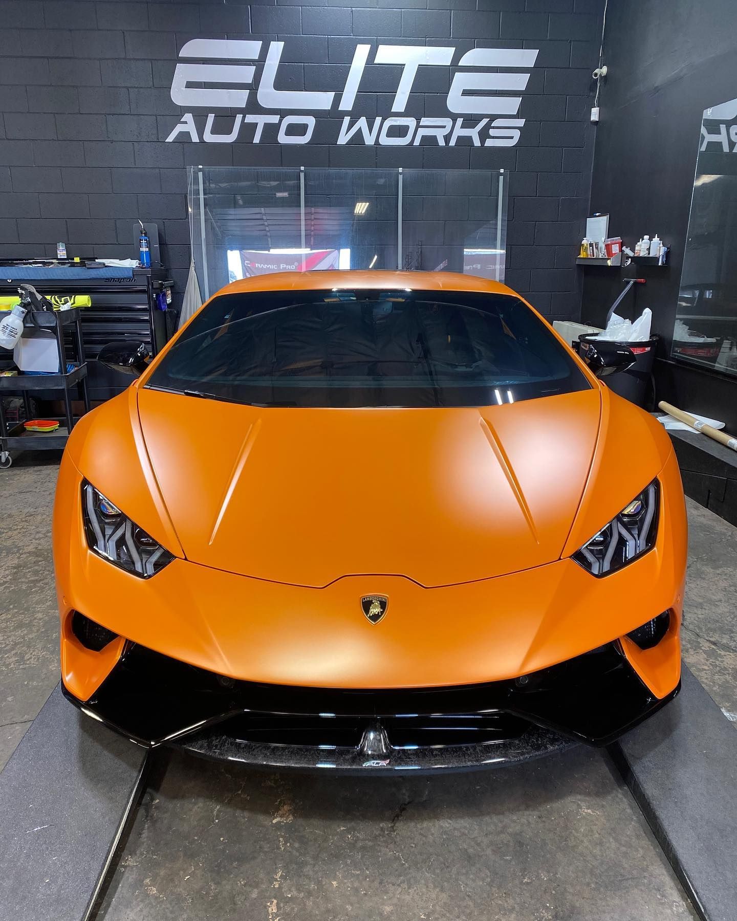 Orange Lamborghini parked indoors at Elite Auto Works garage