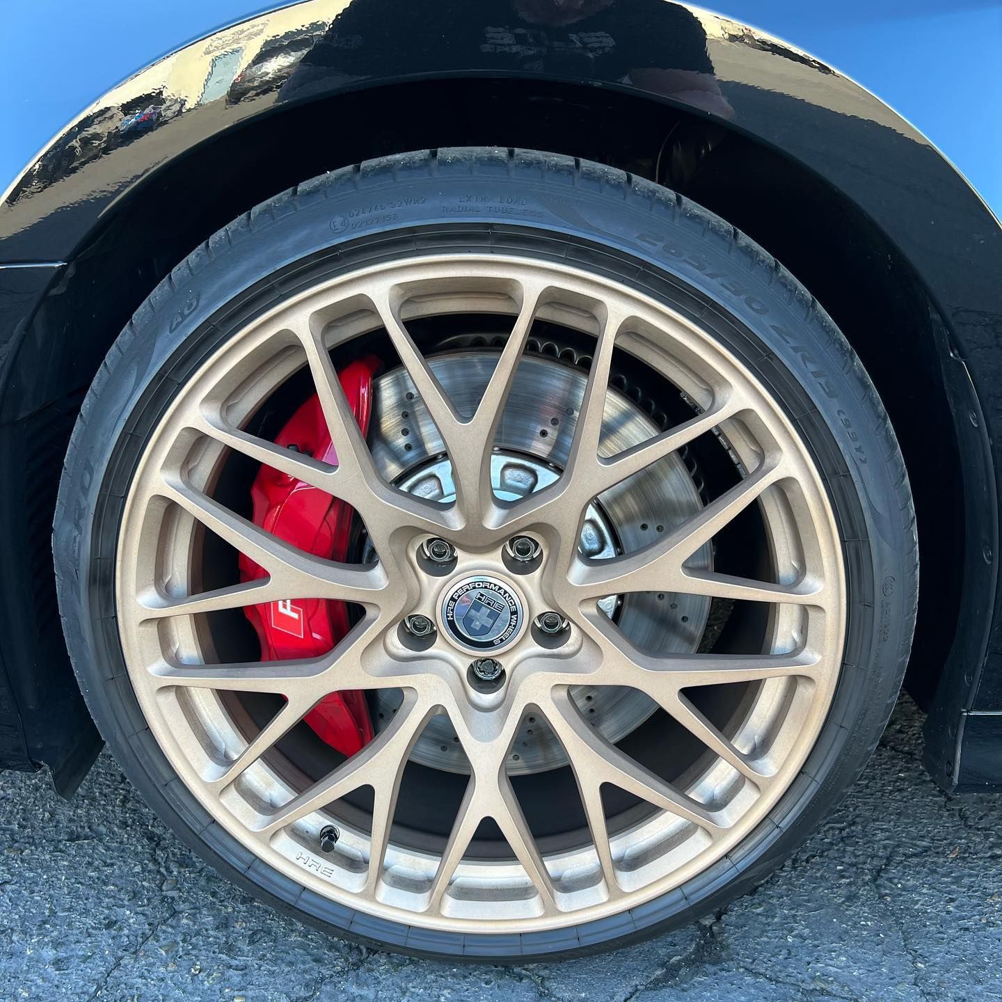 Close-up of a car wheel with silver multi-spoke rim and red brake caliper