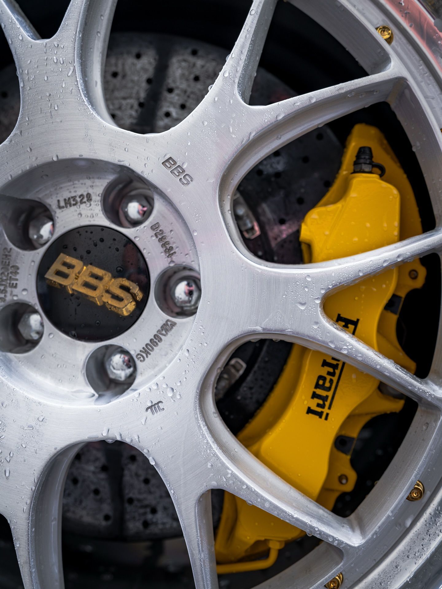 Close-up of a silver BBS wheel with a yellow Brembo brake caliper behind it.