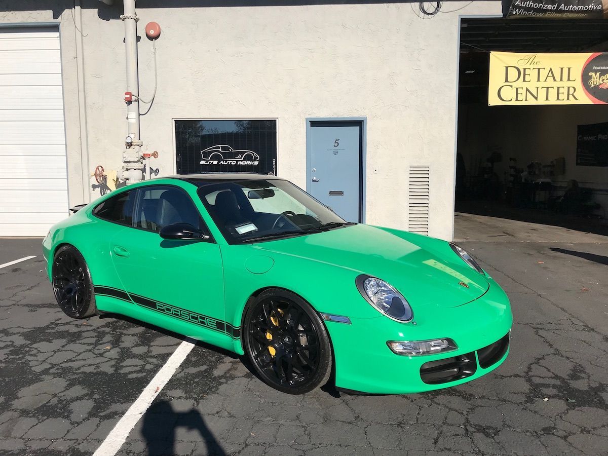 Bright green sports car parked outside a building with a Detailing Center sign