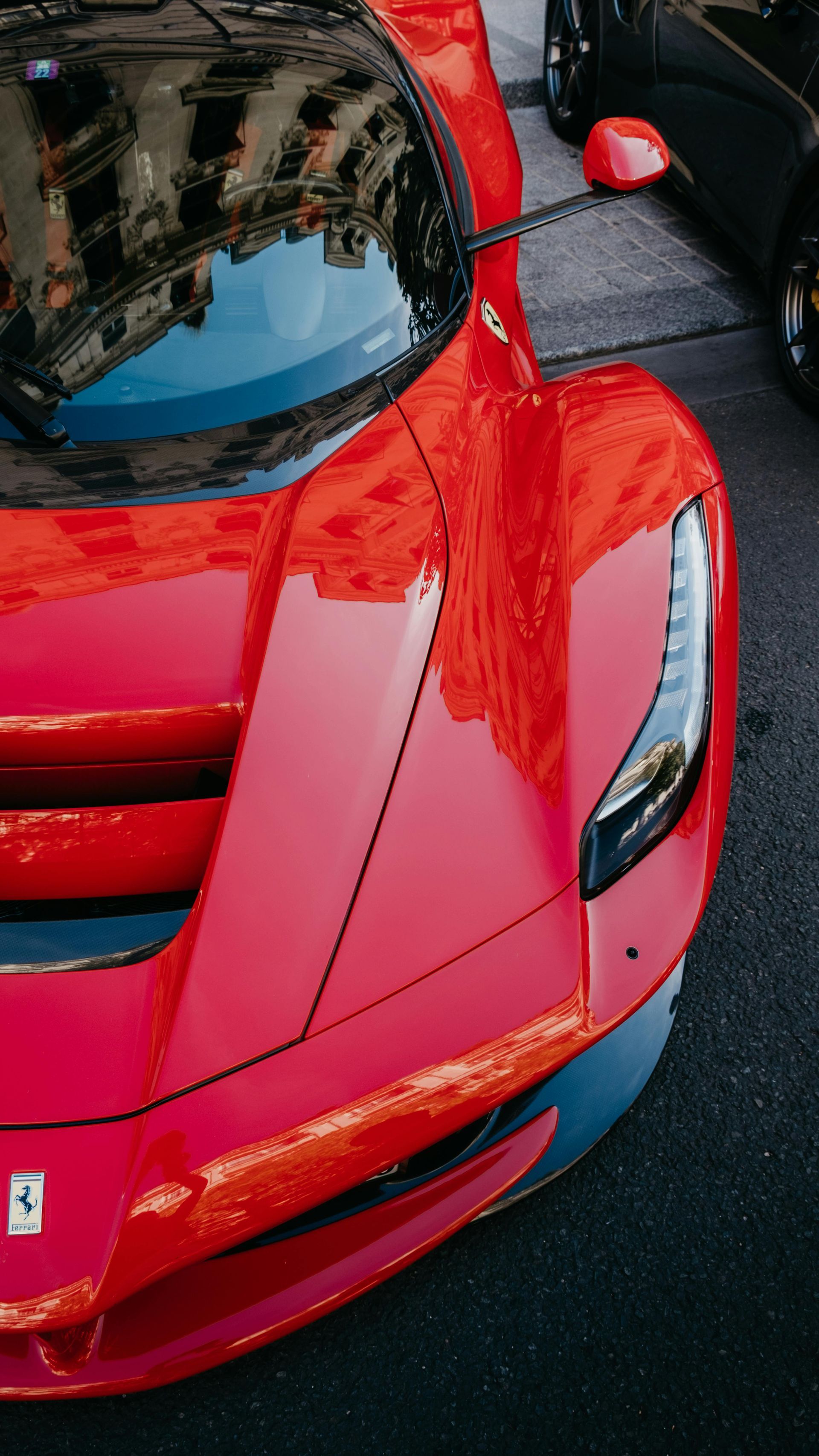 Crowd gathered around two matte black and purple supercars at a car show