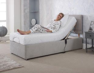 Person reclining on a white adjustable chaise lounge in a bright bedroom
