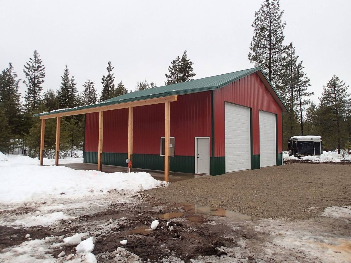A red building with a green roof is surrounded by snow