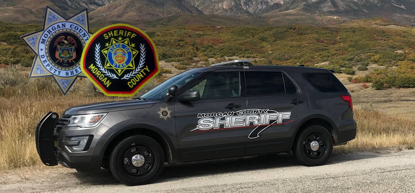 Morgan County Sheriff's patrol SUV parked outdoors with county badges against a mountainous backdrop.