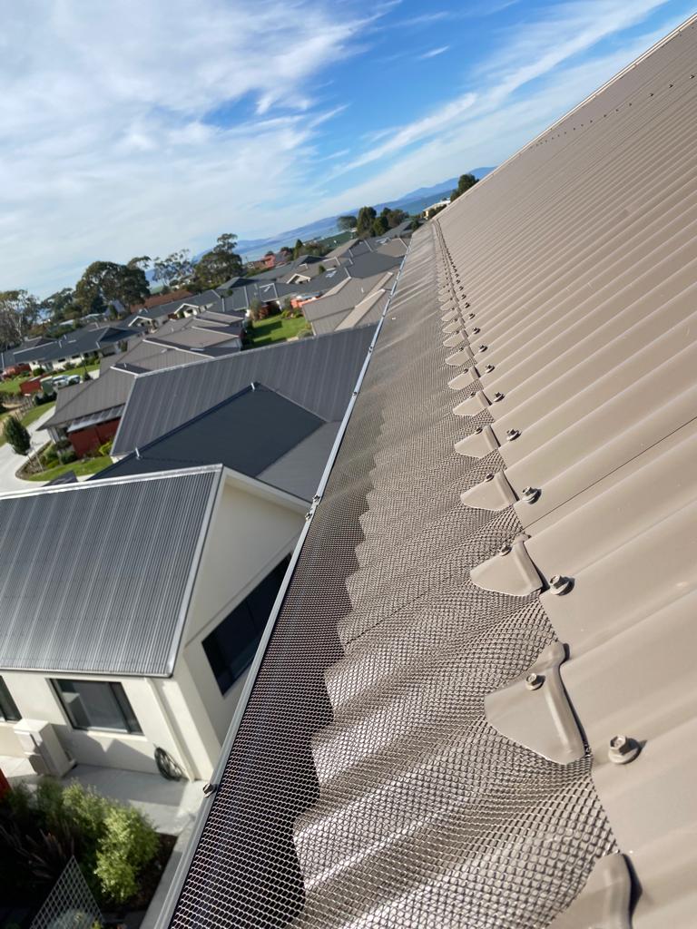An aerial view of a roof with a gutter guard on it.