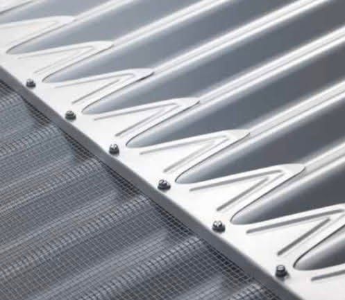 A close up of a metal roof with a mesh screen attached to it.