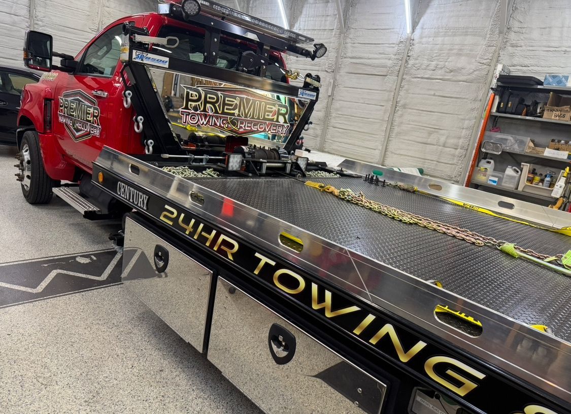A red tow truck parked inside a garage, displaying 