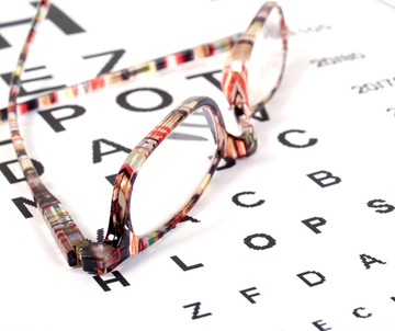 Eyeglasses resting on a letter chart for vision testing