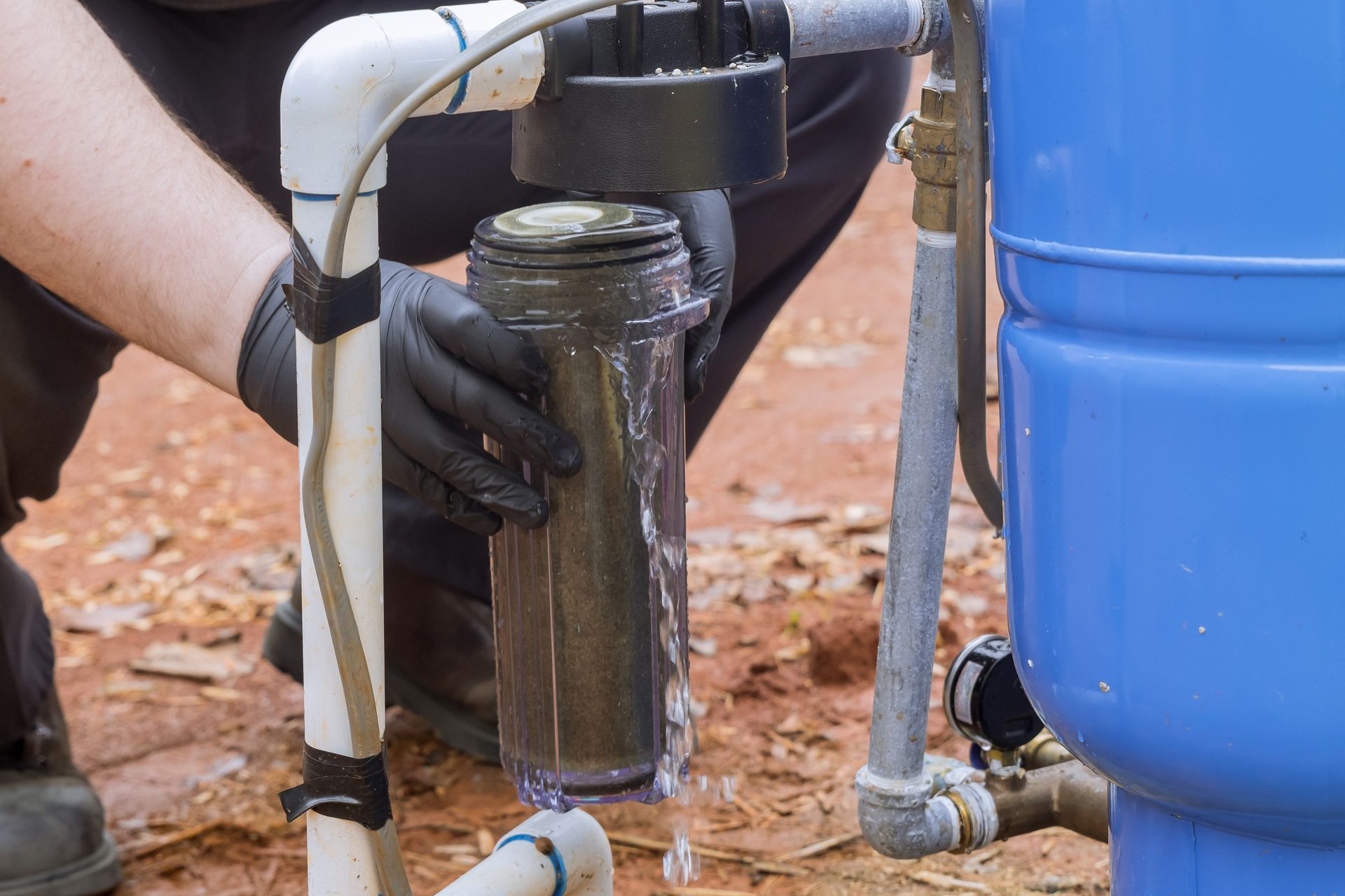 A close-up of a professional replacing a water filter from equipment.