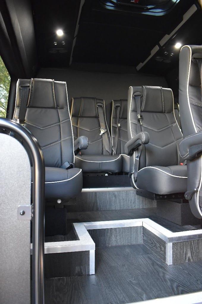 The inside of a bus with a lot of seats and stairs.