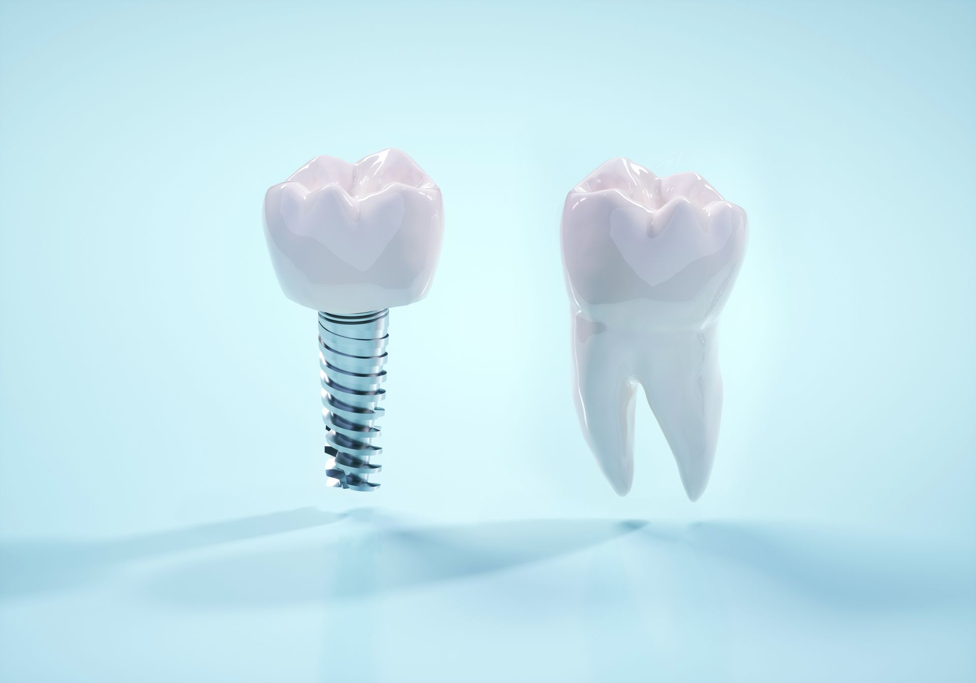 Un impianto dentale e un dente naturale a confronto, su uno sfondo azzurro.