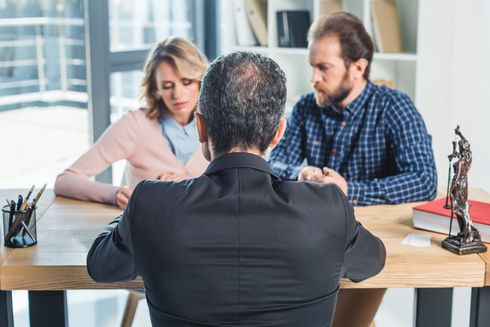 A man is sitting at a table with a woman and a man.