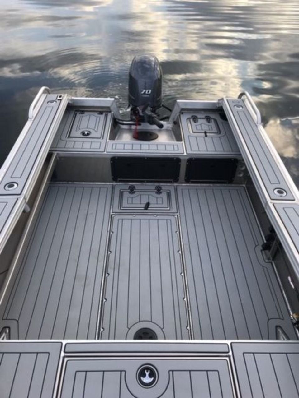 A boat with a motor is floating on top of a body of water.