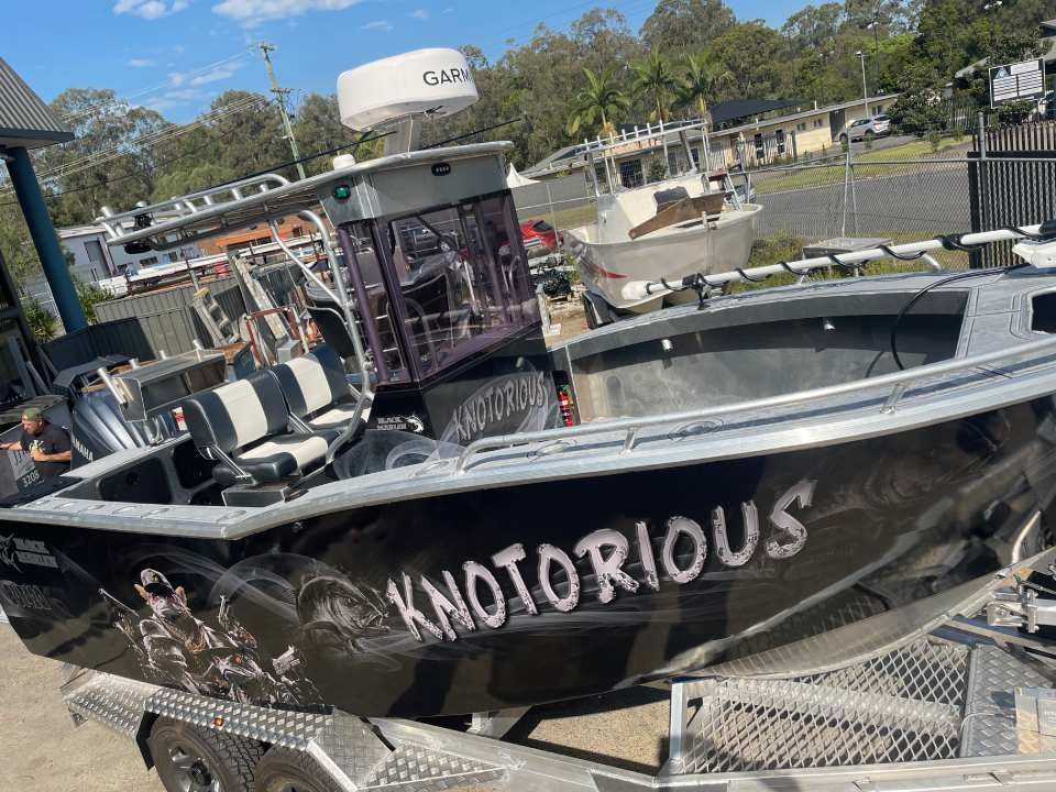 A boat is being lifted into the water on a trailer.