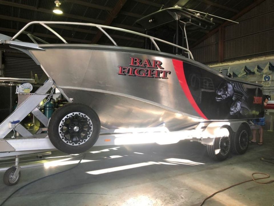 A boat on a trailer that says bar rocket on it