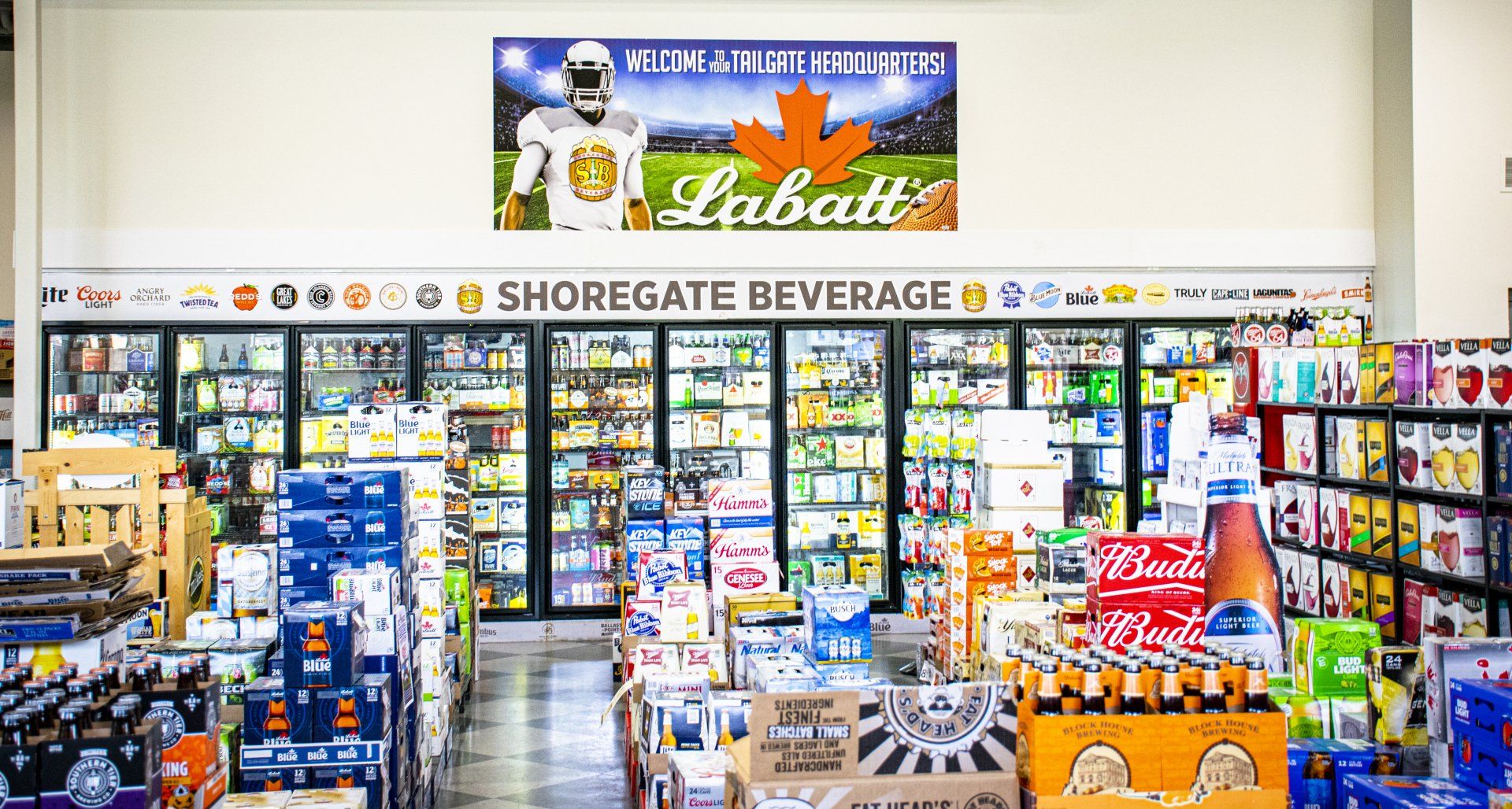 Beverage store interior with refrigerators, displays of beer and drinks, and a Labatt beer sign.
