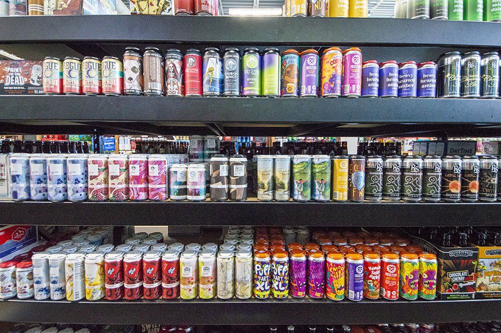 Shelves stocked with colorful beverage cans, in a store setting.