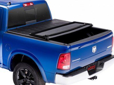 Blue pickup truck with black Extang tonneau cover, partially open.