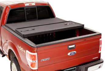 Red pickup truck with a black Extang cover partially open.