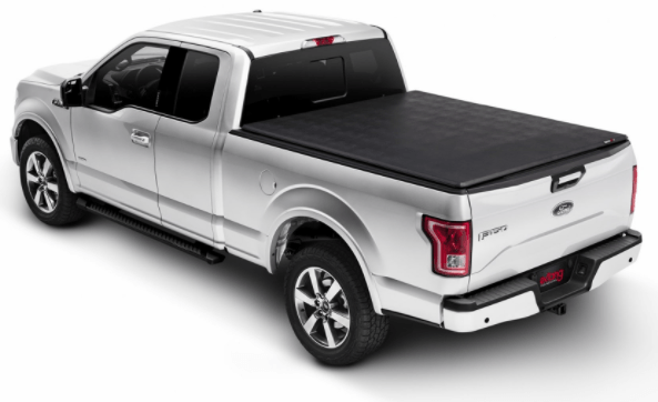 Silver Ford F-150 pickup truck with a black, retractable Extang bed cover, viewed from the rear.