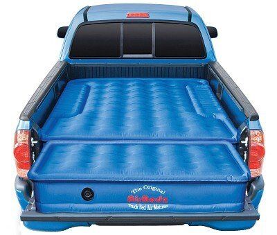 Blue truck bed air mattress in a pickup truck. Made to fit around wheel wells.