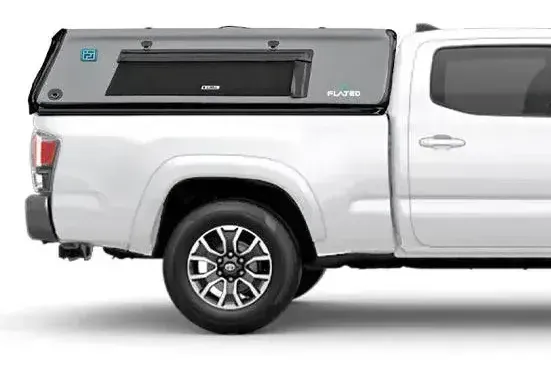 Gray truck bed camper on a white Toyota Tacoma pickup truck.