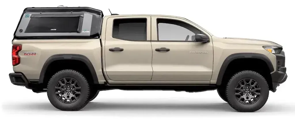 Tan pickup truck with black wheels and a flated air-topper truck cap.