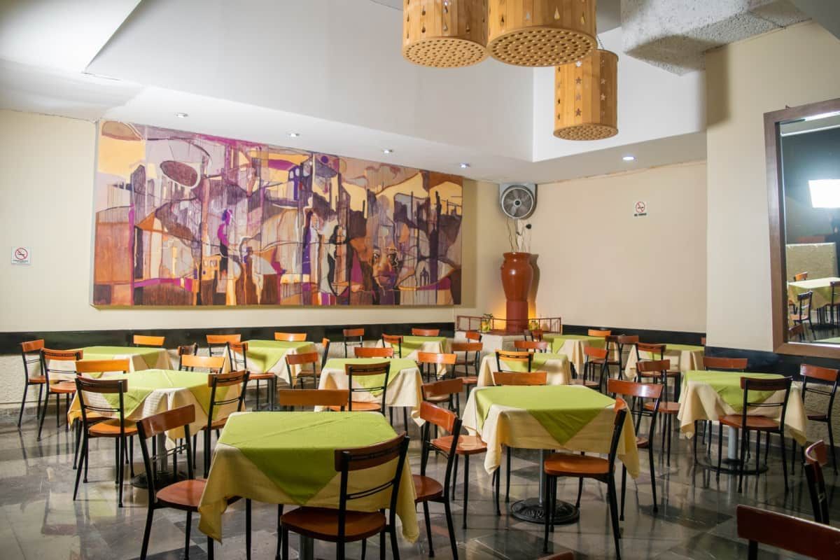 Un restaurante con mesas y sillas y un cuadro en la pared.