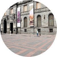 Un grupo de personas camina frente a un gran edificio.