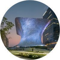 Un gran edificio se ilumina por la noche en un círculo.