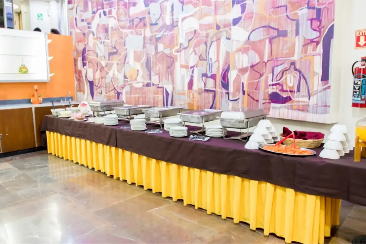 Una mesa de buffet larga con platos y utensilios sobre ella en un restaurante.